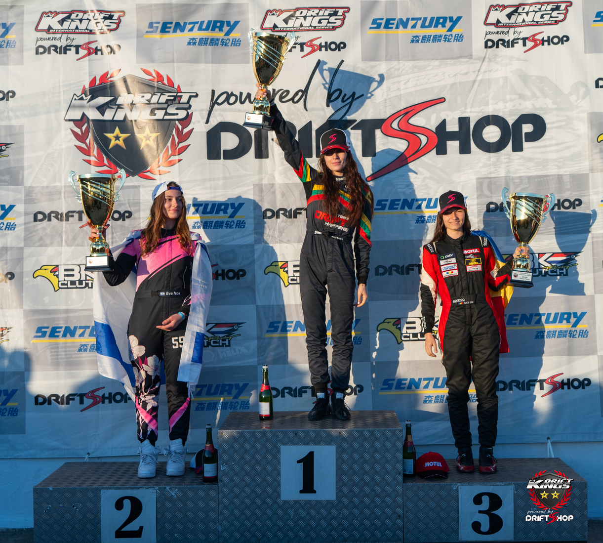 Sandra Janusauskaite celebrating her fourth consecutive Queen title alongside Eva Nox and Alice Ene